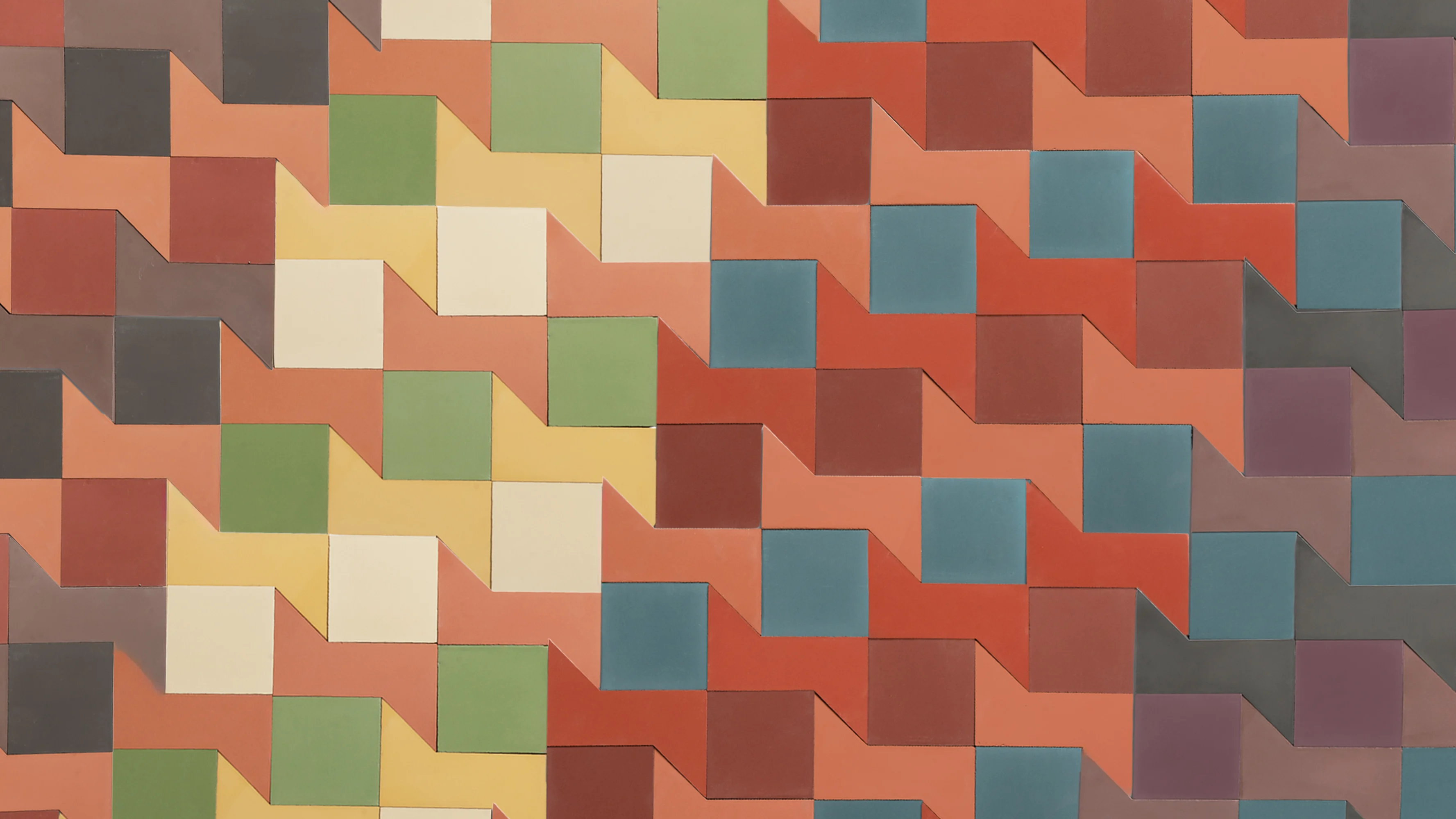 A geometric pattern of colorful tiles arranged in rows, featuring shades of red, orange, yellow, green, blue, and brown. The tiles have a stepped, zigzag design that creates a dynamic visual effect.